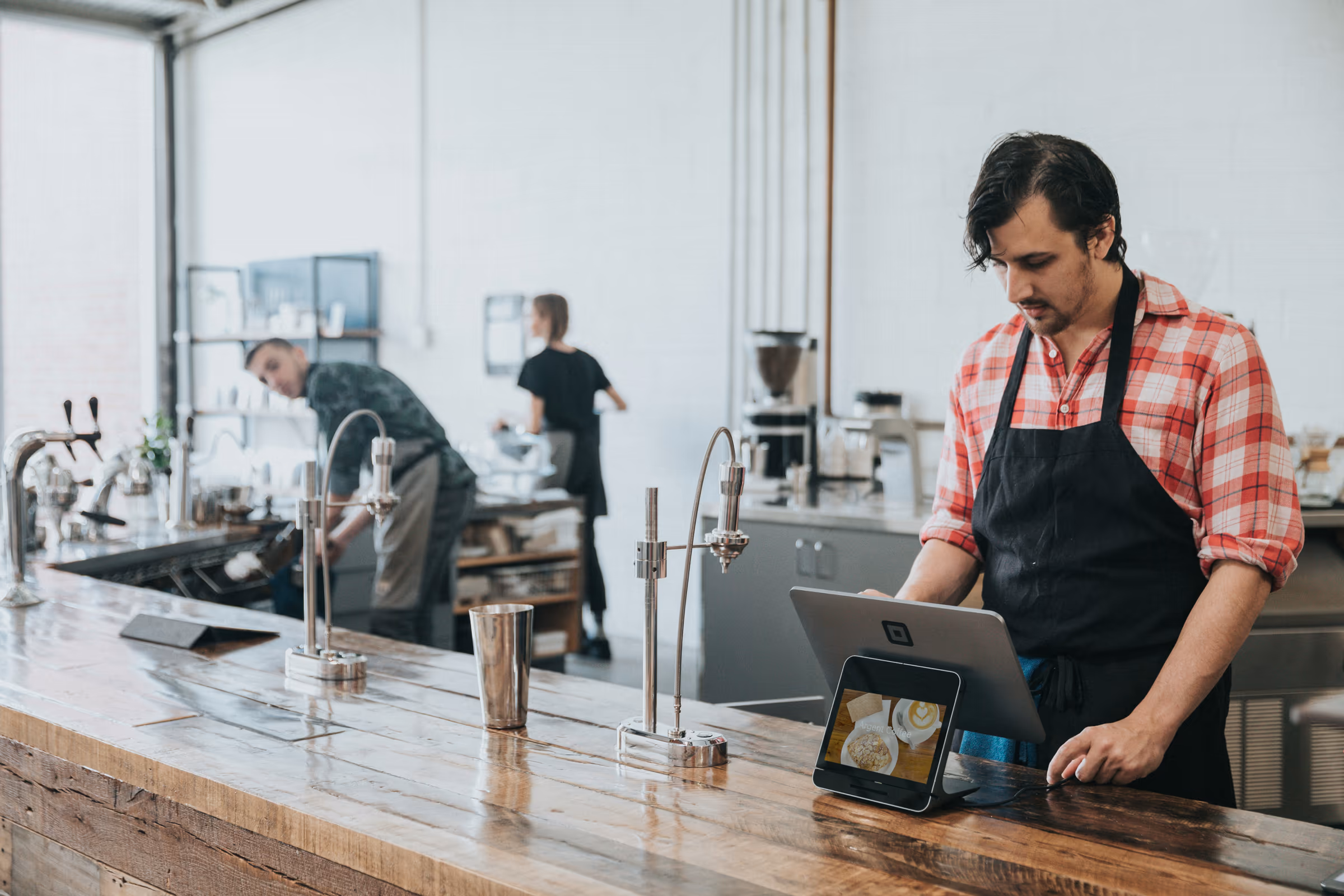 A barista working at a till on a coffee shop counter